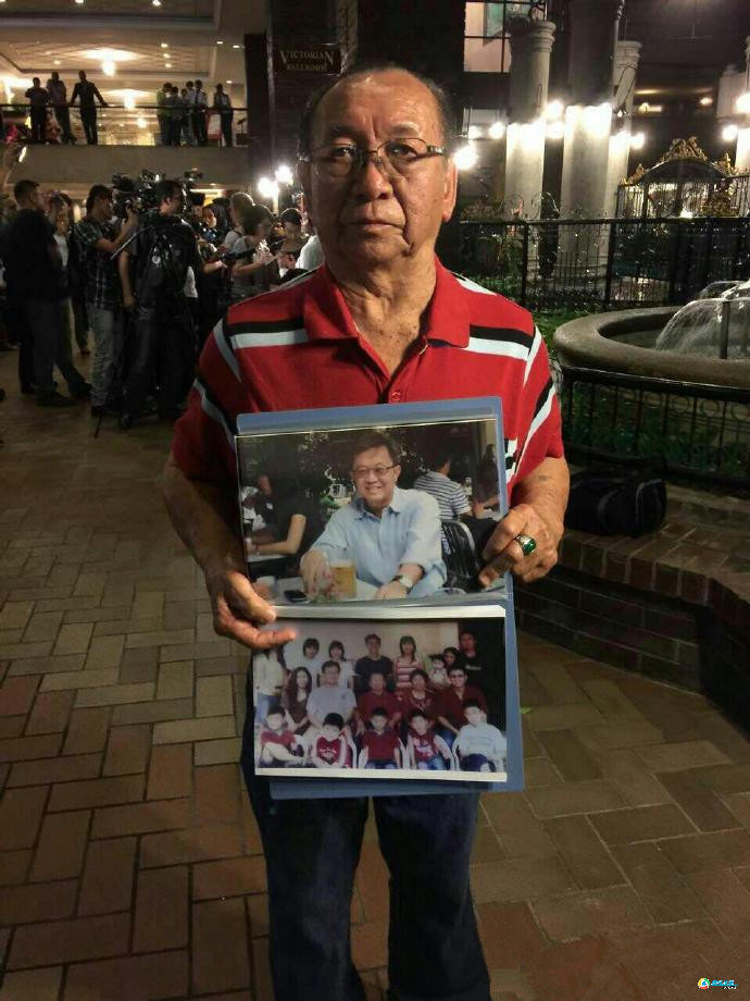 Ngày 30/1, một người đàn ông cầm ảnh của người thân trên chuyến bay MH370, từ chối thông báo tất cả hành khách trên chuyến bay đã thiệt mạng. (Nguồn: QQ)