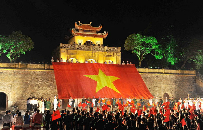 Lễ truyền lá cờ rộng 500m2, nặng 37kg tại điểm cầu Hoàng thành Thăng Long. (Ảnh: Minh Đức/TTXVN)