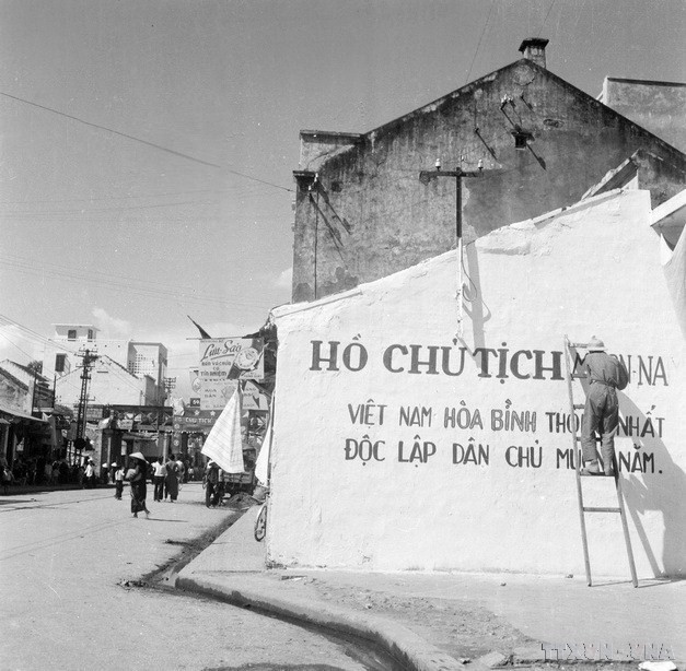 Nhân dân viết khẩu hiệu đón chào bộ đội về giải phóng Thủ đô (1954). (Ảnh: Tư liệu TTXVN)