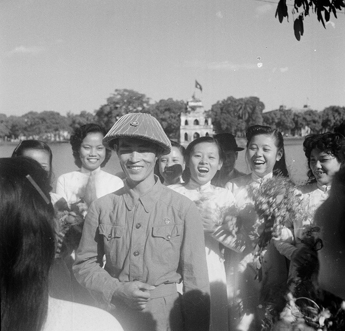 Nữ sinh Hà Nội đón chào Thiếu tướng Vương Thừa Vũ, Chủ tịch Ủy ban Quân chính Hà Nội, người dẫn đầu đoàn quân chiến thắng về giải phóng Thủ đô. (Ảnh: Tư liệu TTXVN)