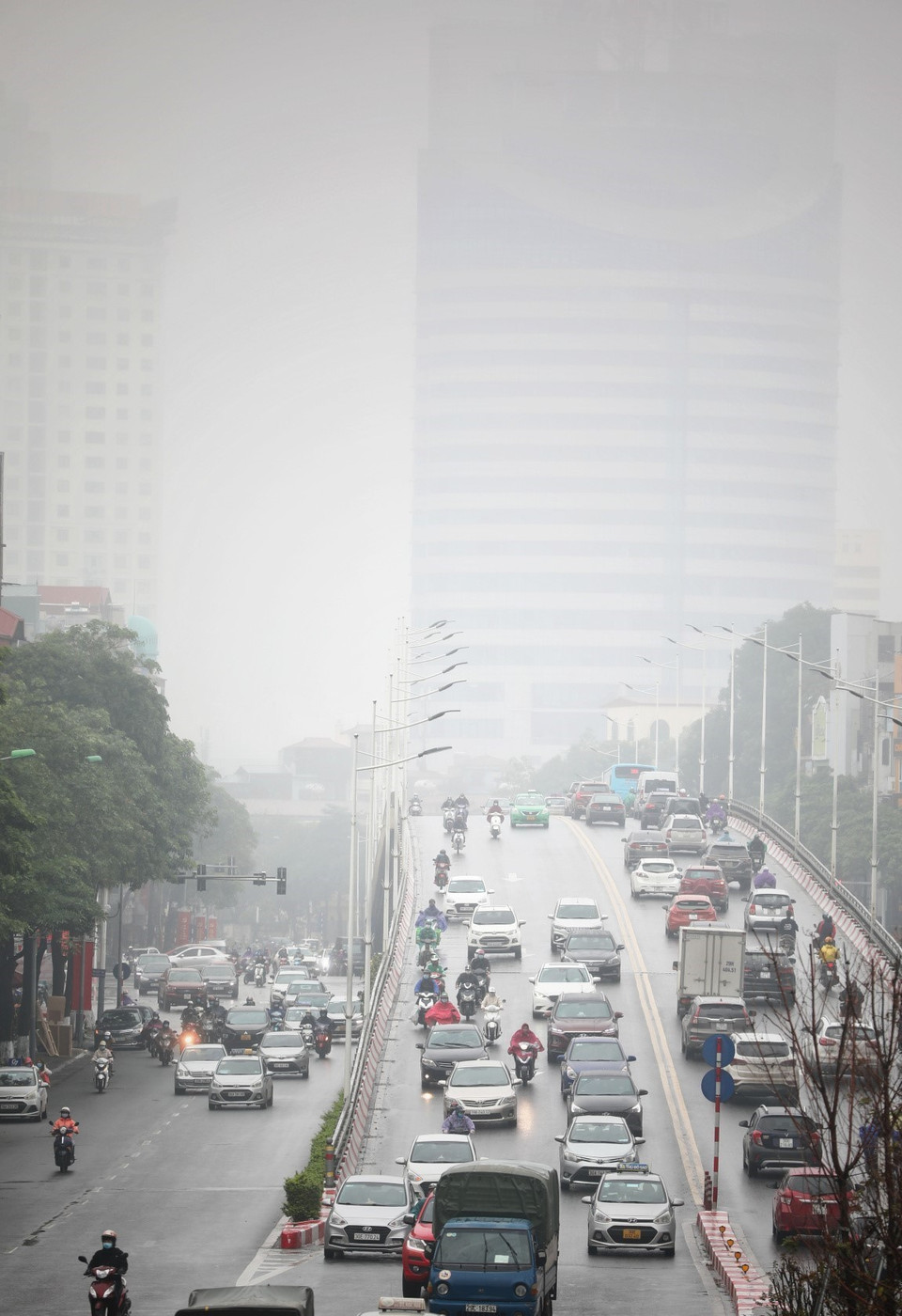 Tại khu vực Trần Duy Hưng sương mù dày đặc xuất hiện từ sáng sớm khiến tầm nhìn bị hạn chế đối với người tham gia giao thông. (Ảnh: Thành Đạt/TTXVN)