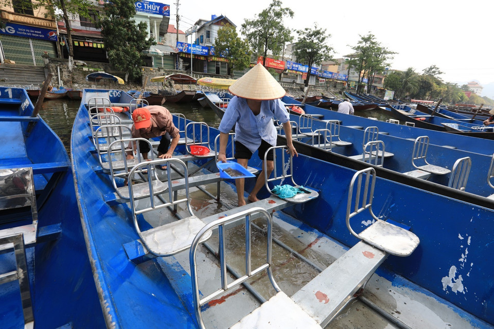Những người lái đò dọn dẹp, lau rửa thuyền chuẩn bị đón du khách ngày khu di tích thắng cảnh Chùa Hương mở cửa trở lại. (Ảnh: Thành Đạt/TTXVN)