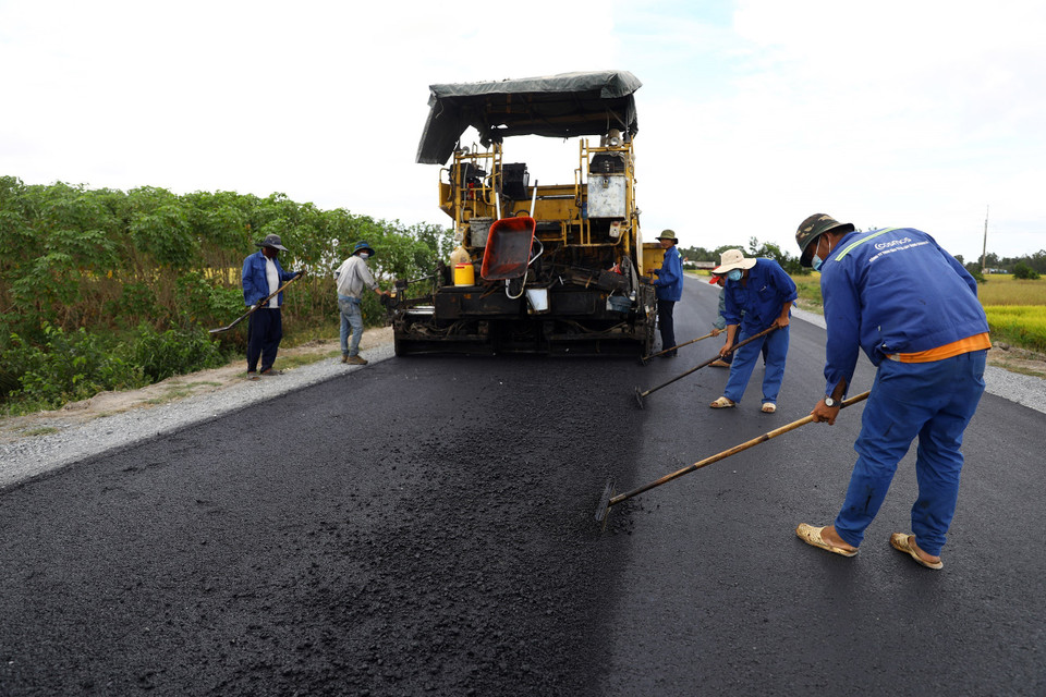 Nhà thầu đang khẩn trương hoàn thiện những lớp nhựa cuối cùng trên tuyến. (Ảnh: Huy Hùng/TTXVN)