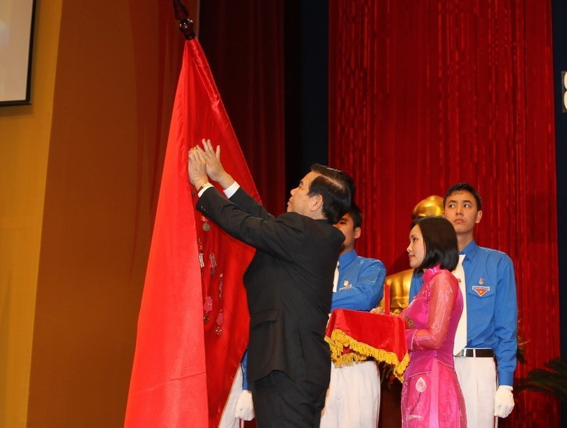 Chủ tịch nước Nguyễn Minh Triết gắn Huân chương Sao Vàng lên cờ truyền thống của Đoàn thanh niên Cộng sản Hồ Chí Minh tại Lễ kỷ niệm 80 năm thành lập Đoàn (26/3/1931-26/3/2011). (Ảnh: Trí Dũng/TTXVN)
