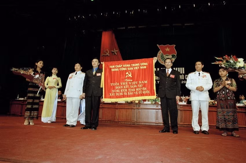Đại hội Đoàn toàn quốc lần thứ VIII đã mở ra một trong mới trong lịch sử phát triển của Đoàn TNCS HCM. Đại hội đã phát động phong trào lớn "Thi đua, tình nguyện xây dựng và bảo vệ Tổ quốc" và kêu gọi tuổi trẻ Việt Nam cùng xiết chặt tay dưới lá cờ vinh quang của Đoàn, nguyện đi theo con đường cách mạng của Đảng, Bác Hồ và nhân dân ta đã lựa chọn. Trong ảnh: Tổng Bí thư Nông Đức Mạnh trao bức trướng cho Đoàn Thanh niên Cộng sản Hồ Chí Minh tại Đại hội Đoàn Thanh niên Cộng sản Hồ Chí Minh lần thứ VIII (2002). (Ảnh: Minh Điền/TTXVN)