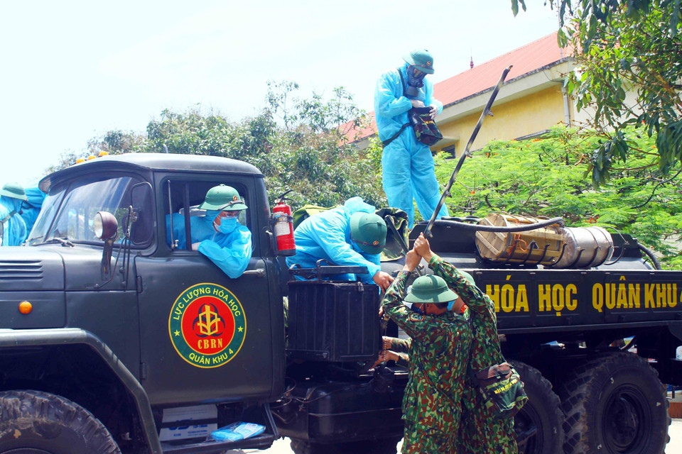 Lực lượng Quân khu 4 chuẩn bị trang thiết bị để tiến hành phun hóa chất, khử khuẩn tại các trường học trên địa bàn thị xã Hoàng Mai. (Ảnh: Tá Chuyên/TTXVN)