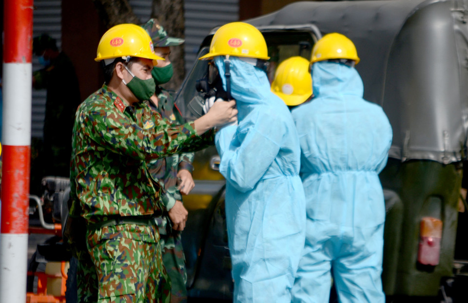 Sáng 6/5/2021, lực lượng Hóa học (Quân khu 5) tiến hành công tác tiêu độc, khử trùng, phòng ngừa COVID-19 tại khu vực xung quanh vũ trường New Phương Đông (đường Đống Đa, quận Hải Châu, thành phố Đà Nẵng). Hai xe phun xịt hóa chất chuyên dụng cùng hàng chục chiến sỹ đã phun xịt khử khuẩn khoảng 5.000m2 mặt đường, ngõ hẻm, các tòa nhà liền kề vũ trường. Trước đó, khu vực này đã bị phong tỏa sau khi quản lý ở vũ trường New Phương Đông là bà B.T.T (quê Đồng Nai) có kết quả xét nghiệm dương tính với virus SARS-CoV-2. Trước khi tiến hành phung xịt khử khuẩn, các chiến sỹ lực lượng Hóa Học (Quân khu 5) được mặc đồ bảo hộ đúng quy định. (Ảnh: Quốc Dũng/TTXVN)