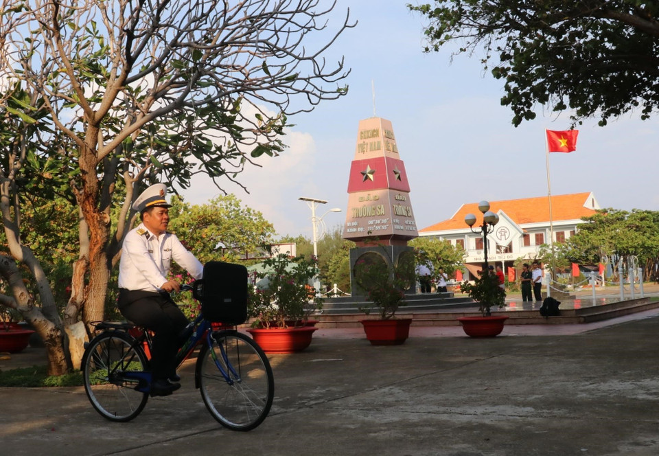 Đại tá Lê Đình Hải, Phó Lữ đoàn trưởng - Lữ đoàn 146 (vùng 4 Hải quân) đạp xe ngang qua cột mốc thị trấn Trường Sa (huyện Trường Sa, tỉnh Khánh Hoà). (Ảnh: Sỹ Tuyên/TTXVN)