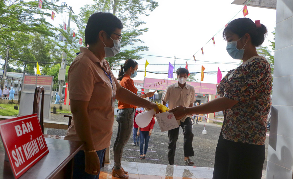 Rửa tay sát khuẩn cử tri tại khu vực bỏ phiếu cố định trước khi bỏ phiếu bầu cử. (Ảnh: Duy Khương/TTXVN)