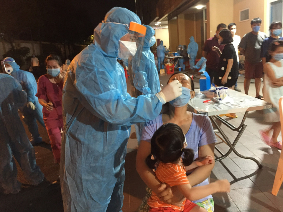 Lực lượng y tế triển khai lấy mẫu xét nghiệm cho toàn bộ cư dân Chung cư Sen Xanh. (Ảnh: Hứa Chung/TTXVN)