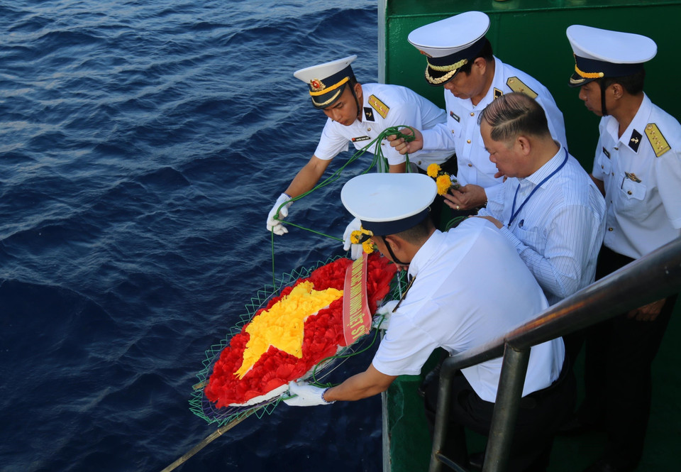 Chuẩn đô đốc Phan Tuấn Hùng - Phó Tư lệnh Quân chủng Hải quân, Quân đội nhân dân Việt Nam cùng cán bộ, chiến sỹ thả vòng hoa hình cờ Tổ quốc xuống biển tưởng niệm các liệt sỹ đã hi sinh trên quần đảo Trường Sa. (Ảnh: Sỹ Tuyên/TTXVN)