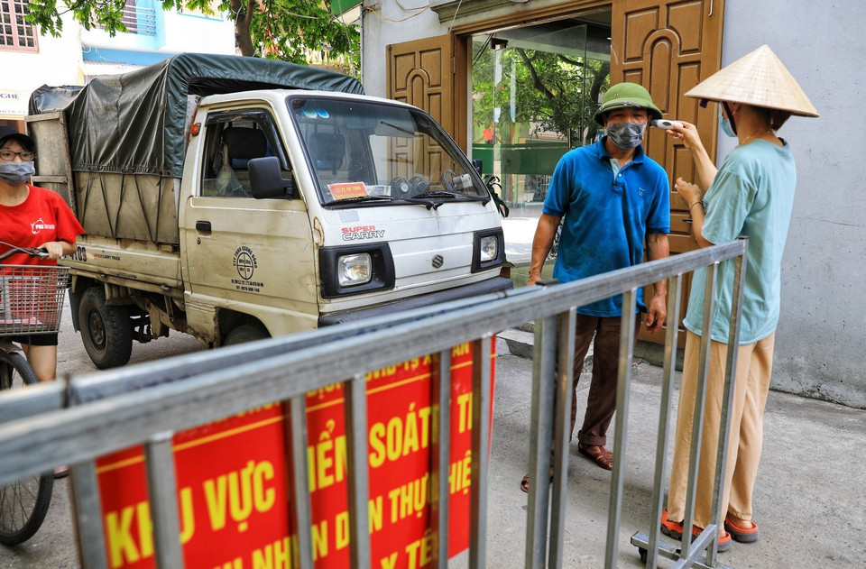 Các chủ phương tiện ra vào thôn đều phải xuống khai báo y tế, kiểm tra thân nhiệt cẩn thận. (Ảnh: Thành Đạt/TTXVN)