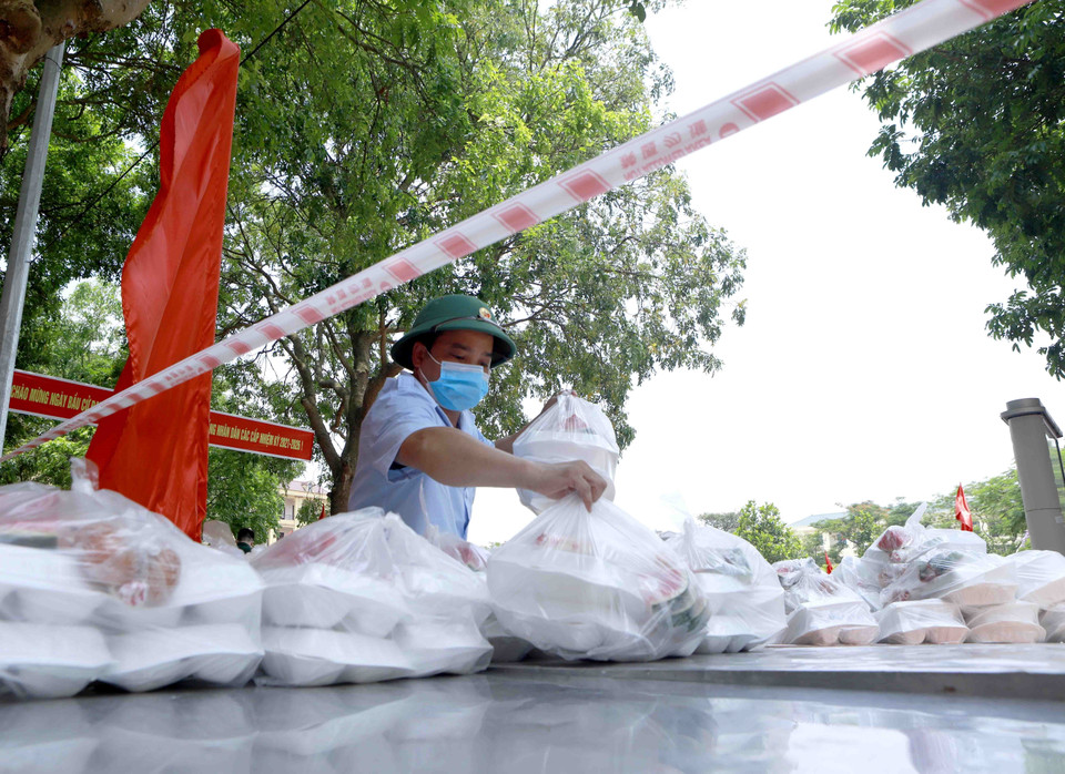 Anh nuôi Trung đoàn 834 chuyển các suất ăn tới vị trí quy đinh cho công dân khu cách ly. (Ảnh: Hoàng Hùng/TTXVN)