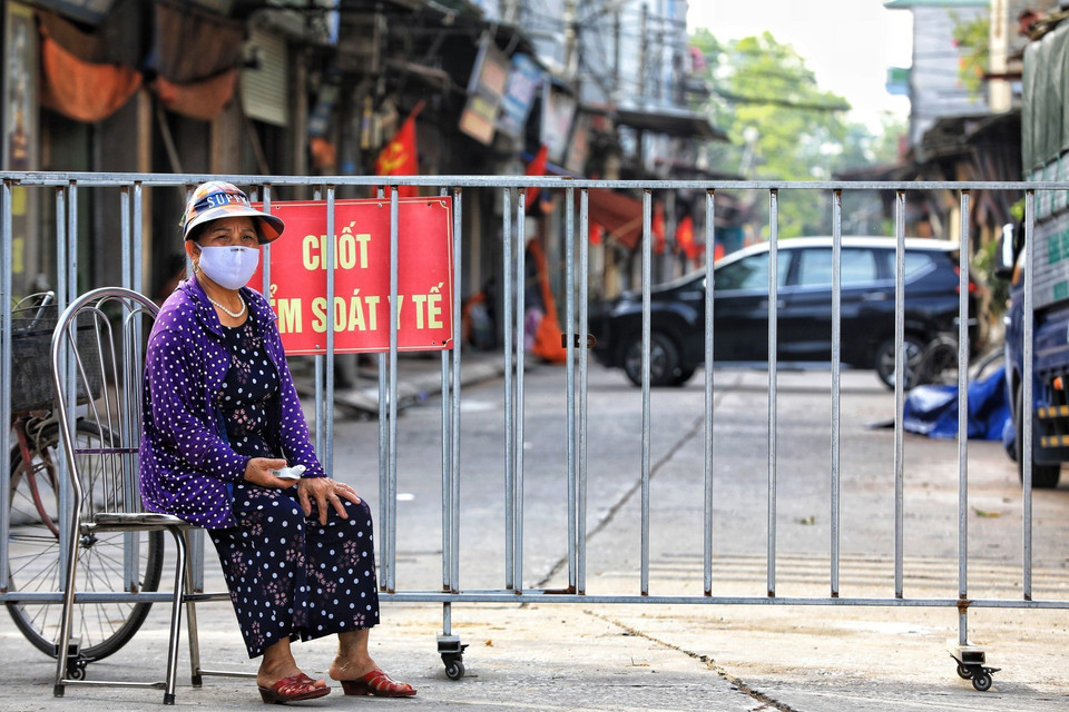Dưới nhiệt độ nắng nóng gần 40 độ C, nhưng các tình nguyện viên là các bà, các mẹ trong hội Phụ nữ vẫn tham gia công tác phòng chống dịch của địa phương. (Ảnh: Thành Đạt/TTXVN)