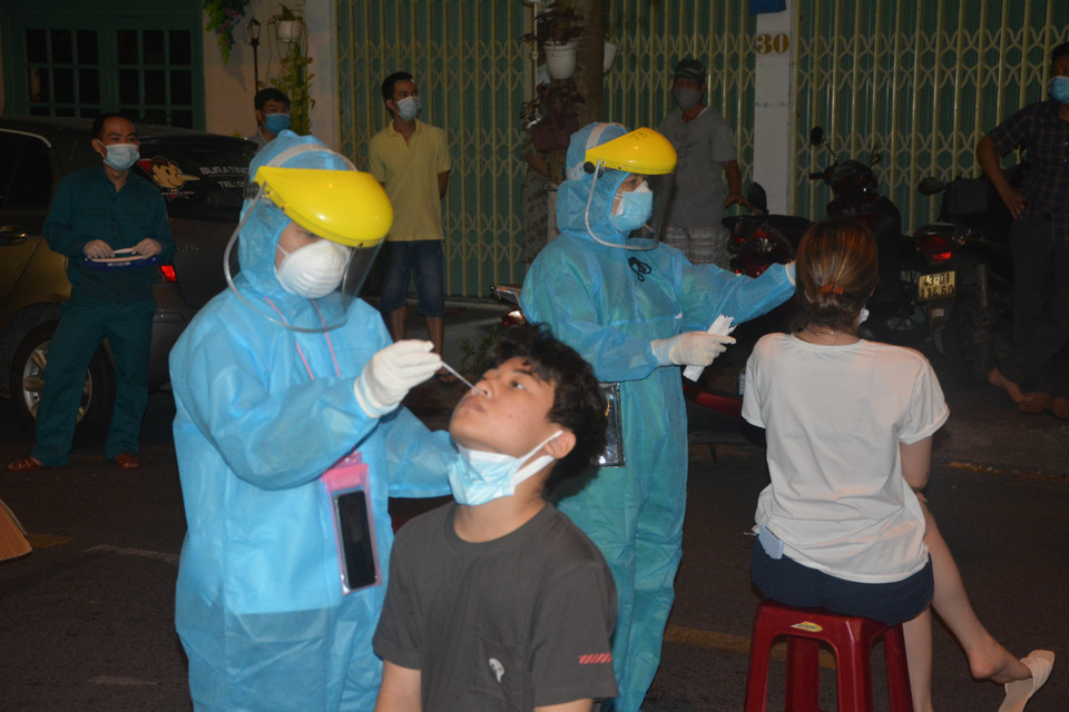 Nhân viên y tế quận Hải Châu khẩn trương lấy mẫu xét nghiệm người dân ngay trong đêm. (Ảnh: Văn Dũng/TTXVN)