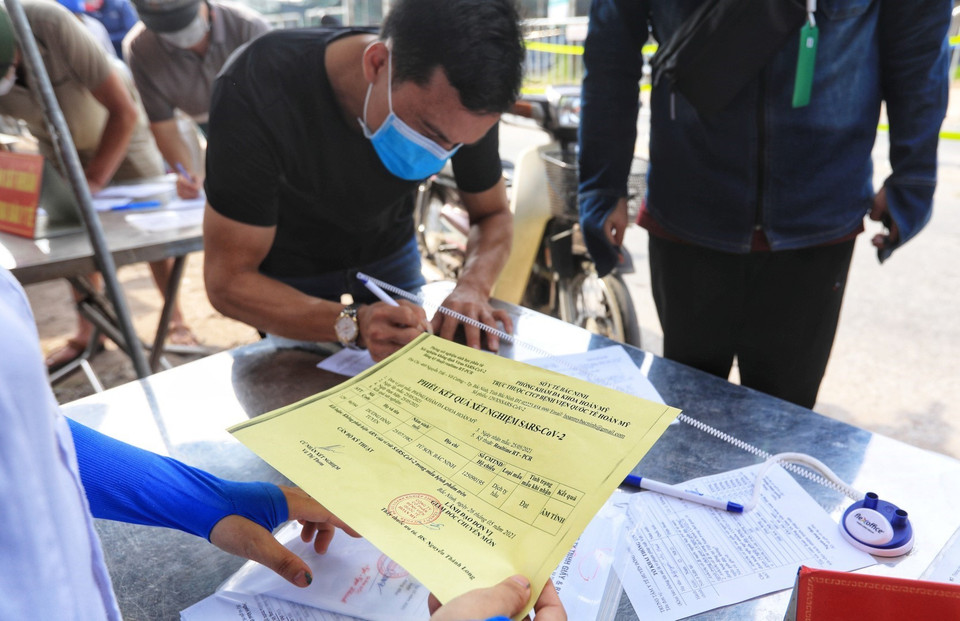 Một số người cung cấp xét nghiệm SARS-CoV-2 âm tính khi đi qua chốt kiểm dịch. (Ảnh: Tuấn Anh/TTXVN)