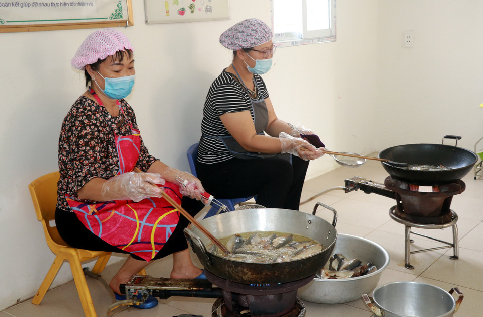Các cô giáo Trường Mầm non thị trấn Cát Thành chuẩn bị bữa ăn, đảm bảo đủ chất, an toàn vệ sinh thực phẩm cho toàn bộ cán bộ chiến sỹ, lực lượng y tế đang làm nhiệm vụ và các trường hợp F1 cách ly, theo dõi sức khỏe tại cơ sở cách ly tập trung huyện Trực Ninh (Nam Định). (Ảnh: Nguyễn Lành/TTXVN)