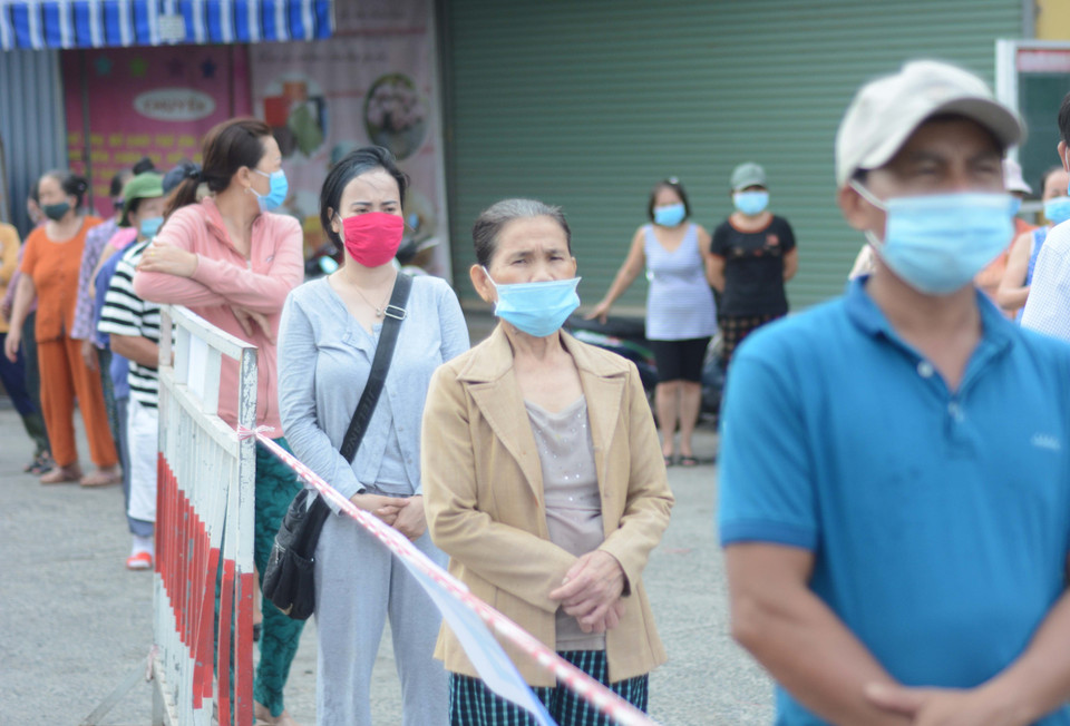 Tiểu thương xếp hàng, giữ khoảng cách khi lấy mẫu xét nghiệm. (Ảnh: Văn Dũng/TTXVN)