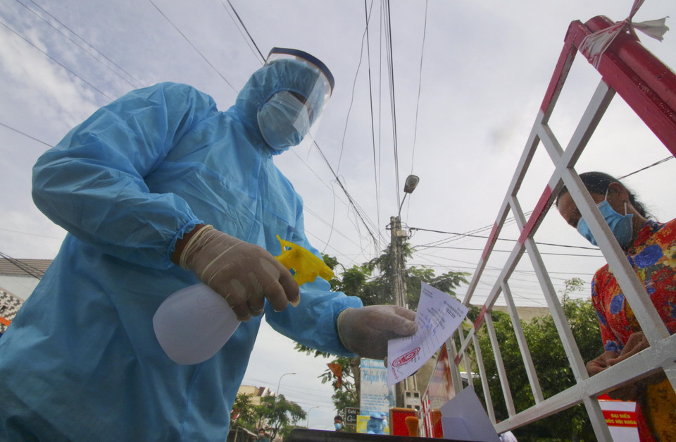 Sát khuẩn phiếu cử tri vùng cách ly y tế trong khu dân cư (khu vực phong tỏa) sau khi bỏ phiếu bầu cử xong. (Ảnh: Duy Khương/TTXVN)