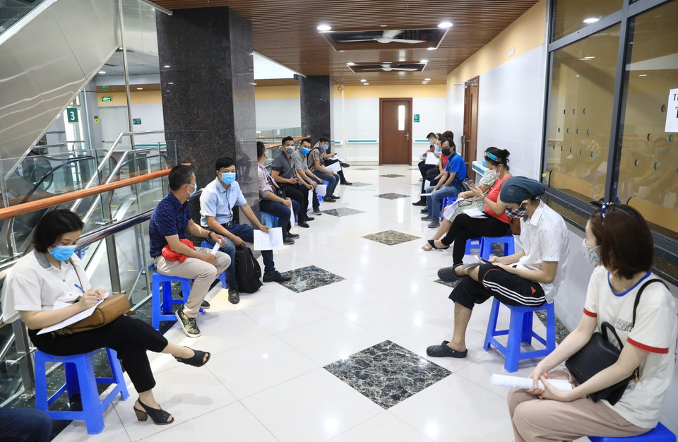 Các phóng viên khi đến tiêm vaccine phòng chống dịch thực hiện ngồi giãn khoảng cách cần thiết đúng quy định. (Ảnh: Thành Đạt/TTXVN)