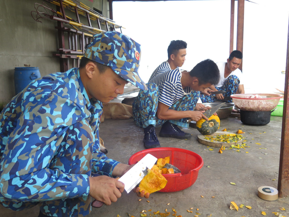 Các chiến sỹ trẻ trên đảo Đá Tây A đang sơ chế thực phẩm, chuẩn bị bữa trưa cho đơn vị, đảm bảo bữa ăn ngon miệng và chất lượng. (Ảnh: Phan Sáu-Sỹ Tuyên-Thắng Trung/TTXVN)