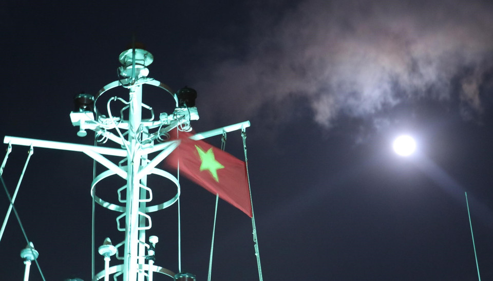 Cờ Tổ quốc trên nóc tàu Trường Sa 571 tung bay phấp phới dưới ánh trăng khi tàu đi trên vùng biển gần đảo Song Tử Tây – quần đảo Trường Sa (huyện Trường Sa, tỉnh Khánh Hoà). (Ảnh: Sỹ Tuyên/TTXVN)