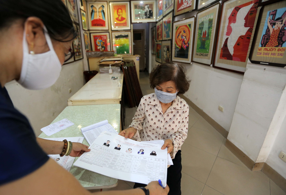 Thẻ cử tri và danh sách chính thức những người ứng cử được đưa đến tận tay cử tri. (Ảnh: Hoàng Hiếu/TTXVN)