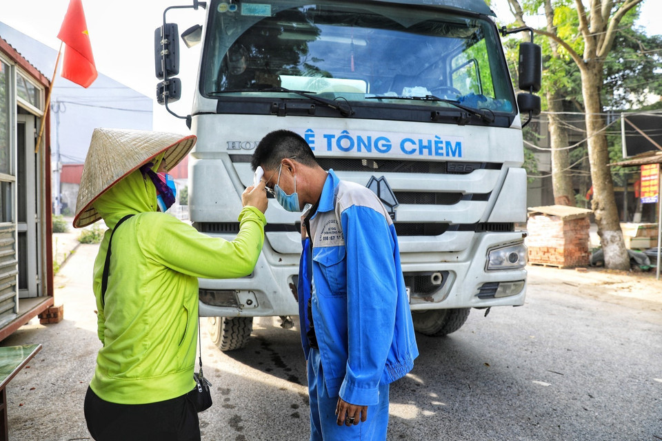 Các chủ phương tiện ra vào thôn đều phải xuống khai báo y tế, kiểm tra thân nhiệt cẩn thận. (Ảnh: Tuấn Anh/TTXVN)
