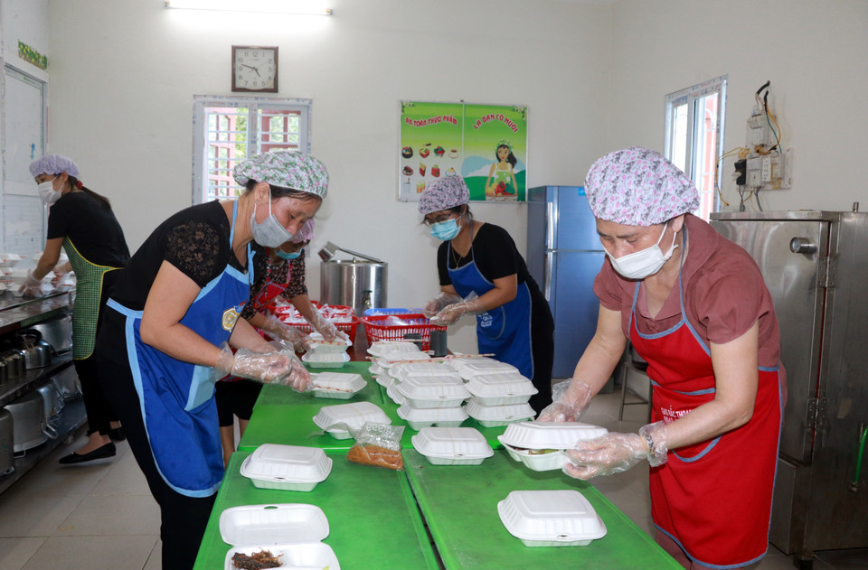Các cô giáo Trường Mầm non thị trấn Cát Thành chuẩn bị bữa ăn đủ chất, an toàn vệ sinh thực phẩm cho toàn bộ cán bộ chiến sỹ, lực lượng y tế đang làm nhiệm vụ và các trường hợp F1 cách ly, theo dõi sức khỏe tại cơ sở cách ly tập trung huyện Trực Ninh (Nam Định). (Ảnh: Nguyễn Lành/TTXVN)