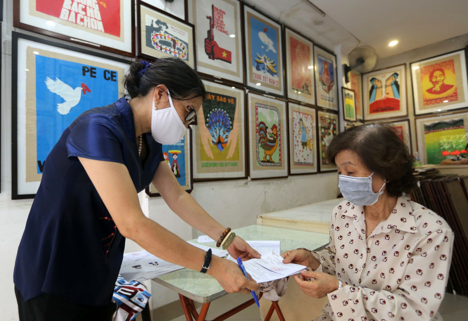 Thẻ cử tri và danh sách chính thức những người ứng cử được đưa đến tận tay người dân. (Ảnh: Hoàng Hiếu/TTXVN)