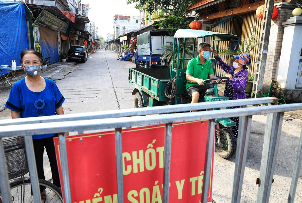 Các bà, các mẹ trong hội Phụ nữ kiểm tra thân nhiệt rất cẩn thận không bỏ sót một ai dù là người thân quen trong thôn. (Ảnh: Thành Đạt/TTXVN)