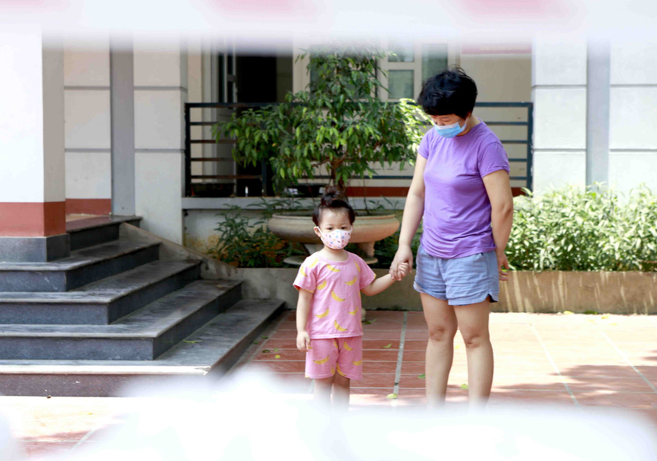 Hai mẹ con chuẩn bị nhận suất ăn trưa tại khu cách ly rung đoàn 834. (Ảnh: Hoàng Hùng/TTXVN)