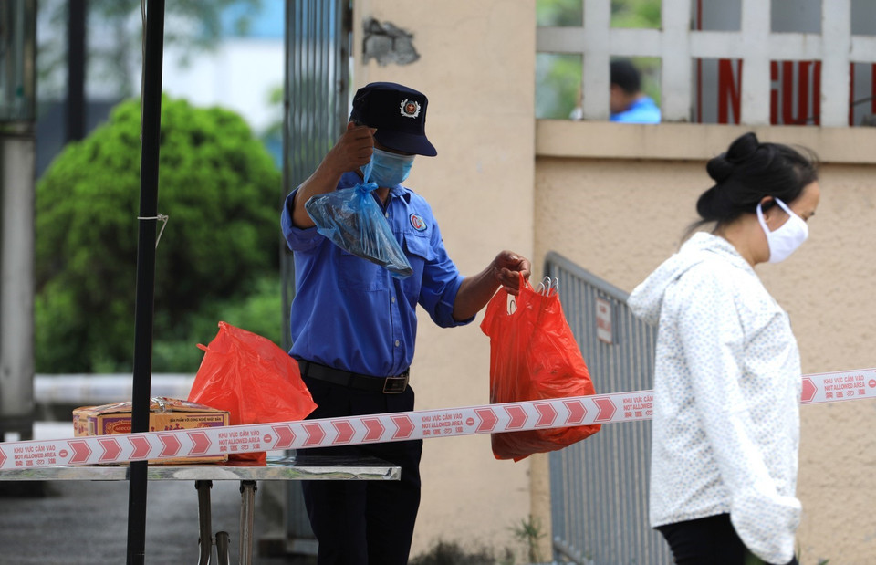 Người nhà tiếp tế nhu yếu phẩm cho bệnh nhân đều phải đặt tại chốt kiểm tra để nhân viên bệnh viện chuyển vào. (Ảnh: Thành Đạt/TTXVN)