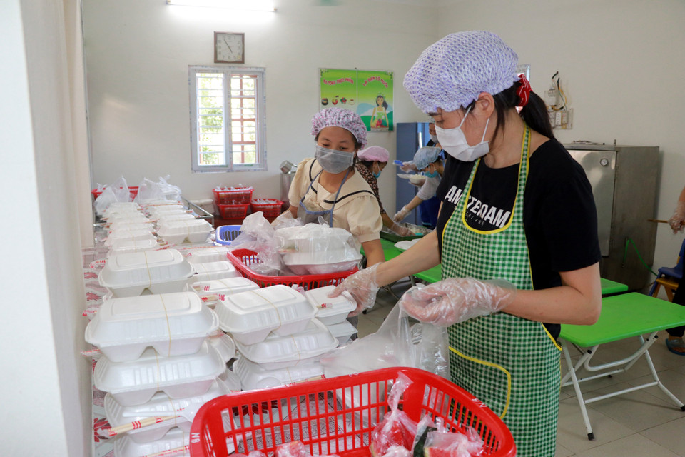 Các cô giáo Trường Mầm non thị trấn Cát Thành có mặt tại trường từ 5 giờ 30 sáng đến 19 giờ để chuẩn bị bữa ăn đảm bảo đủ chất, an toàn vệ sinh thực phẩm cho toàn bộ cán bộ chiến sỹ, lực lượng y tế đang làm nhiệm vụ và các trường hợp F1 cách ly, theo dõi sức khỏe tại cơ sở cách ly tập trung huyện Trực Ninh (Nam Định). (Ảnh: Nguyễn Lành/TTXVN)