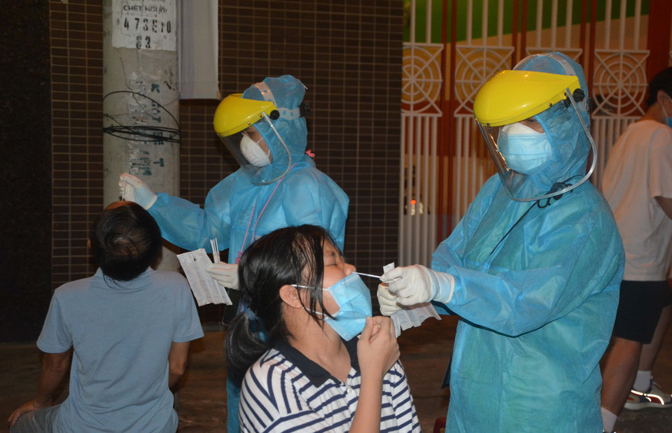 Nhân viên y tế quận Hải Châu khẩn trương lấy mẫu xét nghiệm người dân ngay trong đêm. (Ảnh: Văn Dũng/TTXVN)