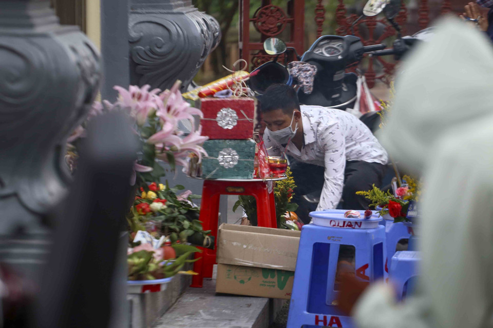 Người dân chuẩn bị đồ lễ trước cổng Phủ Tây Hồ. (Ảnh: Tuấn Đức/TTXVN)