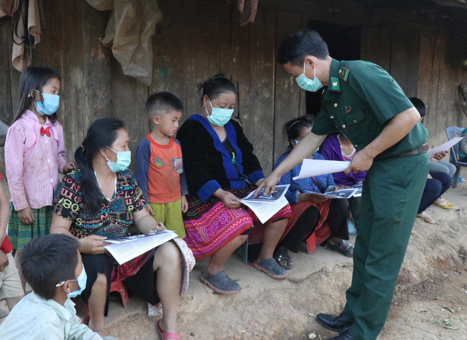 Chiến sỹ Biên phòng Đồn Biên phòng tỉnh Điện Biên tuyên truyền về biện pháp phòng chống dịch COVID-19 cho người dân bản Pá Trả (xã Mường Pồn, huyện Điện Biên) khi đi bầu cử. (Ảnh: Xuân Tiến/TTXVN)