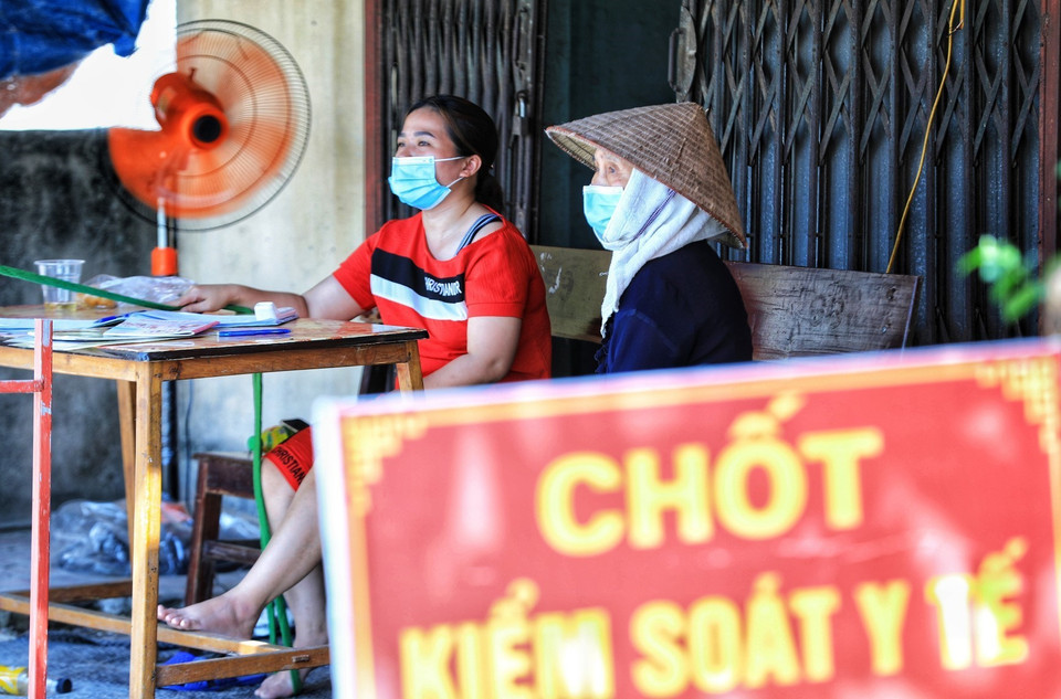 Dưới nhiệt độ nắng nóng gần 40 độ C, nhưng các tình nguyện viên là các bà, các mẹ trong hội Phụ nữ đều công tác phòng chống dịch của địa phương. (Ảnh: Thành Đạt/TTXVN)