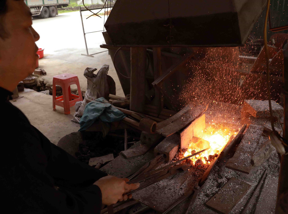 Người dân ở làng nghề rèn nông cụ bằng than củi theo phương pháp truyền thống. (Ảnh: Minh Quyết/TTXVN)