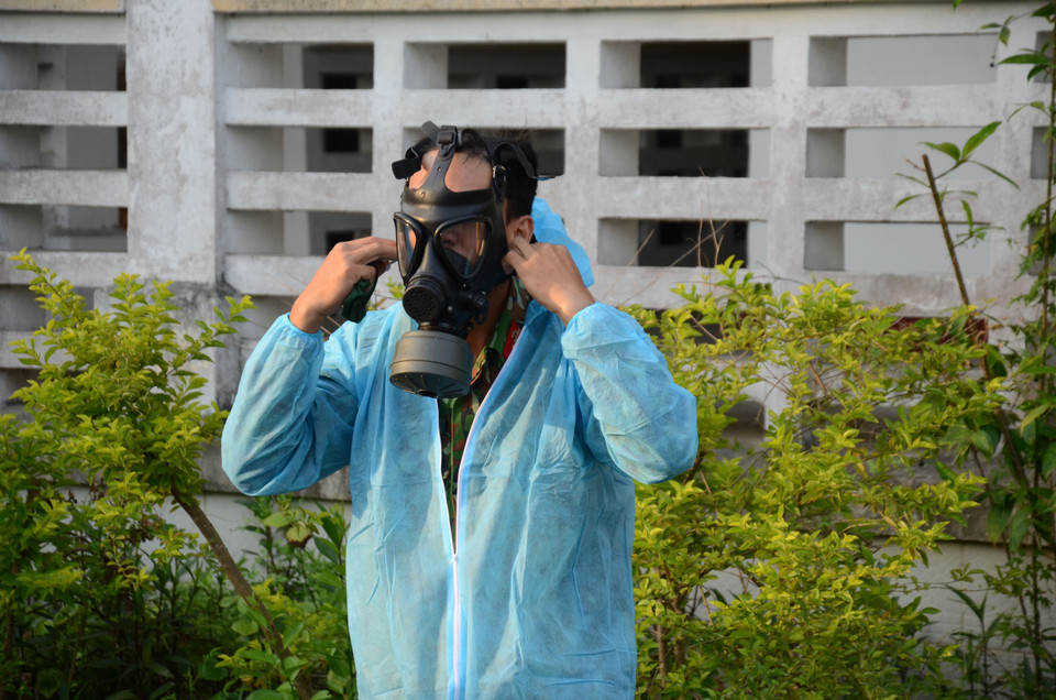 Các chiến sỹ Tiểu đoàn Phòng hóa 78 sử dụng mặt nạ chuyên dụng khi phun xịt khử khuẩn. (Ảnh: Quốc Dũng/TTXVN)