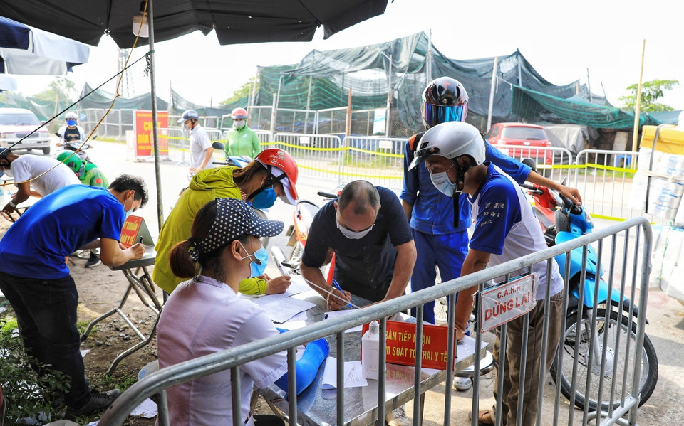 Người dân phải khai báo y tế trước khi qua chốt kiểm dịch tại xã Vân Hà giáp ranh với các xã thuộc huyện Từ Sơn, tỉnh Bắc Ninh. (Ảnh: Tuấn Anh/TTXVN)