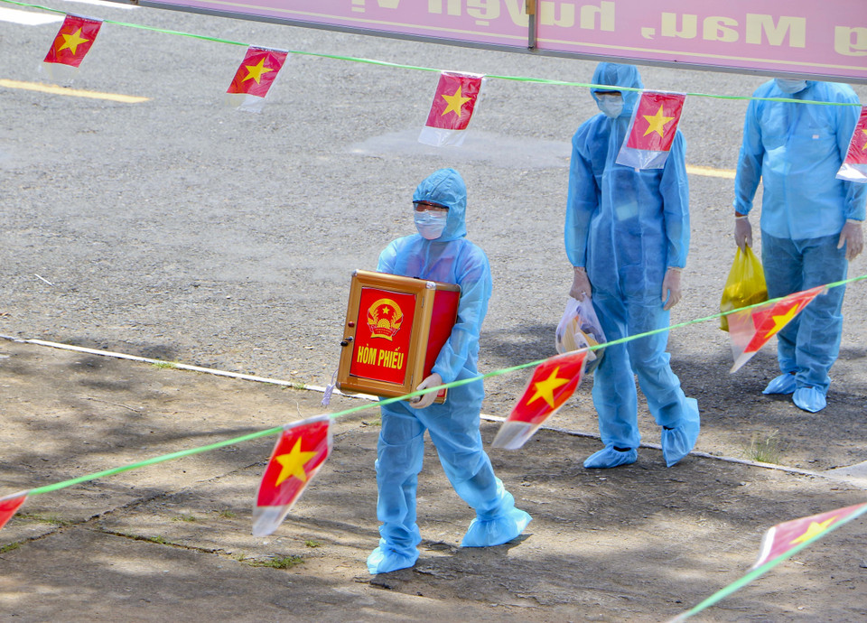 Tổ bầu cử lưu động di chuyển hòm phiếu phụ có khử khuẩn bằng tia cực tím đến cử tri đang thực hiện cách ly tại nhà. (Ảnh: Duy Khương/TTXVN)