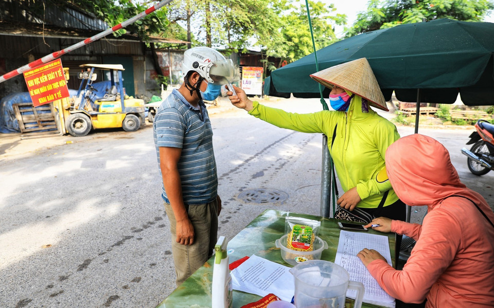 Các chị em trong hội Phụ nữ thôn Thiết Úng, xã Vân Hà, huyện Đông Anh có nhiệm vụ kiểm soát y tế, xác định lịch trình hoạt động của tất cả người và phương tiện đi vào địa bàn huyện. (Ảnh: Thành Đạt/TTXVN)