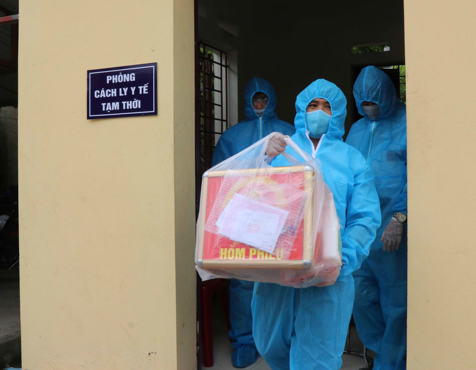 Tổ bầu cử vận chuyển hòm phiếu phụ trong tình huống tổ chức bầu cử cho cử tri cách ly tại nhà. (Ảnh: Thái Hùng/TTXVN)