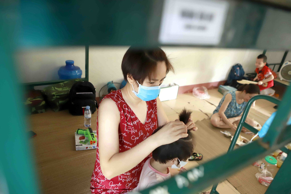 Người mẹ chăm sóc con tại khu cách ly Trung đoàn 834. (Ảnh: Hoàng Hùng/TTXVN)