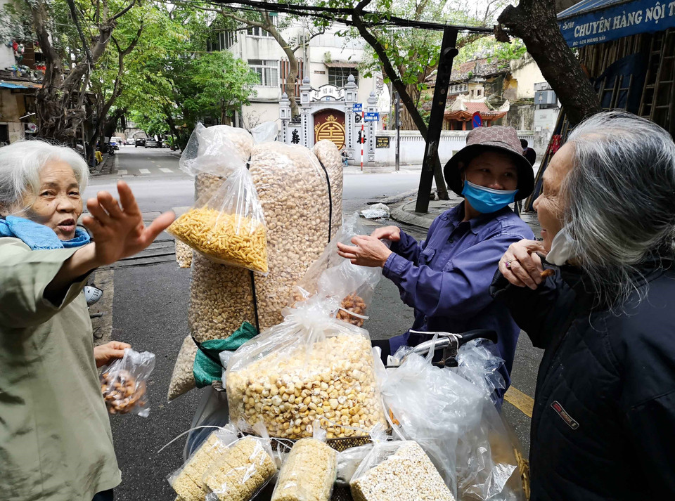 Trong lúc bán hàng, người mua hay người bán vô tình bỏ khẩu trang rất dễ lây lan dịch bệnh. (Ảnh: Thanh Tùng/TTXVN)