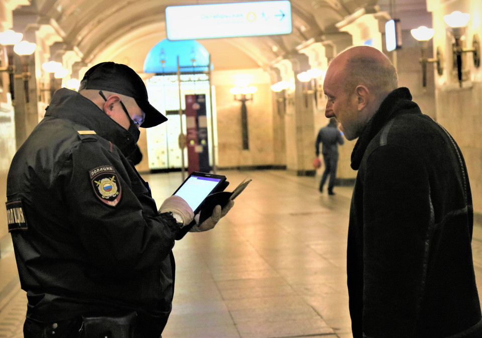 Cảnh sát kiểm tra thẻ thông hành QR của hành khách bằng máy tính bảng. (Ảnh: Duy Trinh/Vietnam+)