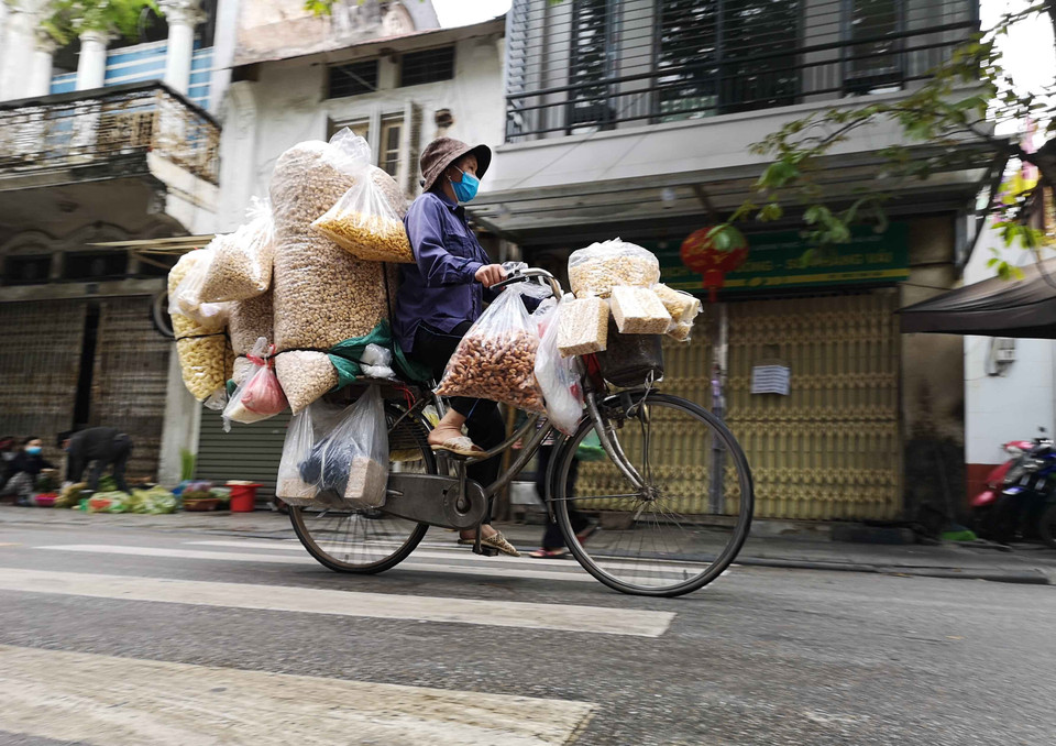 Với phương thức di chuyển thuận lợi, từ xe đẩy, xe đạp hay đôi quang gánh tới xe máy, người bán hàng rong dễ thâm nhập các ngõ, phố của Hà Nội để bán hàng. (Ảnh: Thanh Tùng/TTXVN)