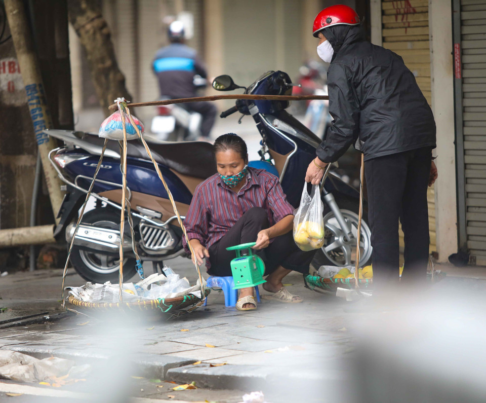 Chiều 12/4, những người bán hàng rong vẫn đi tới nhiều ngõ, phố của Hà Nội để bán hàng tiềm ẩn nguy cơ lây lan dịch bệnh. (Ảnh: Thanh Tùng/TTXVN)