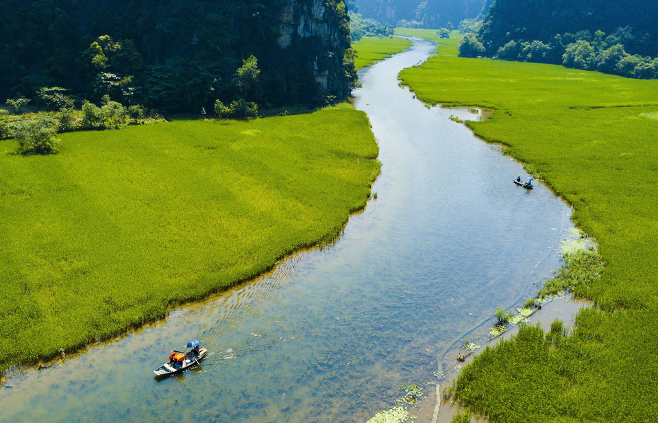 Nhìn từ trên cao xuống những thửa ruộng kéo dài từ trong mép chân núi đá vôi ra gần giữa dòng sông. (Ảnh: Minh Đức/TTXVN)